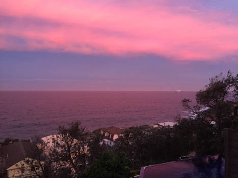 New South Wales - Zonsondergang kleurt de zee roze, cruiseschip vanuit Sydney in de verte